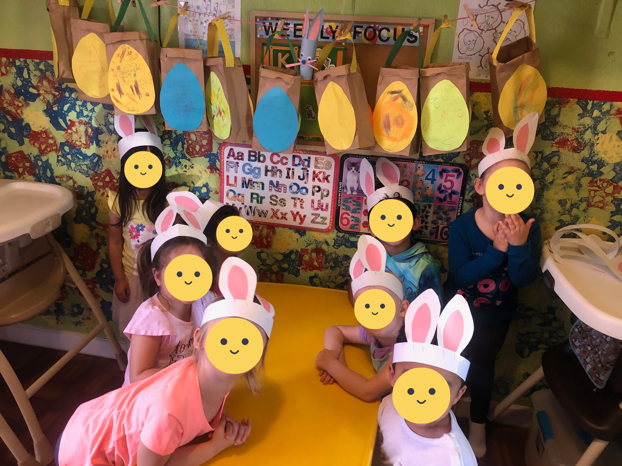 Children sit in the classroom with their constructed bunny ear headbands.